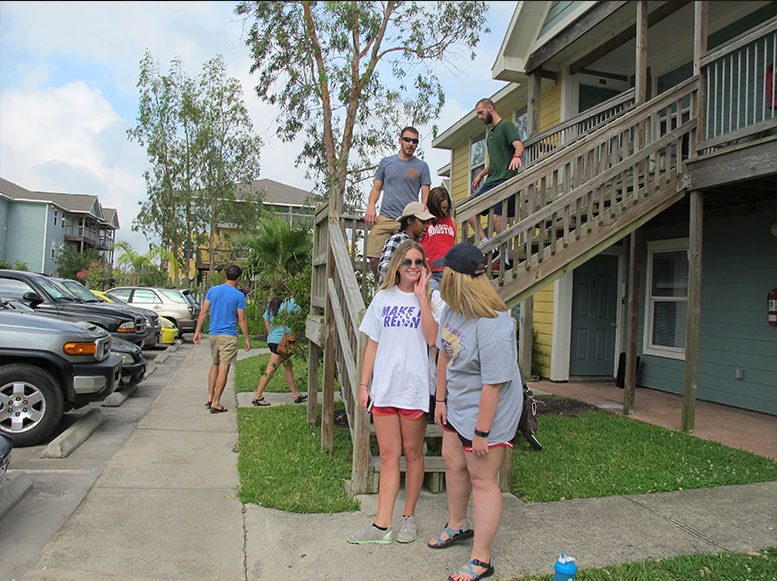 Three UAG residents standing along an apartment walkway
